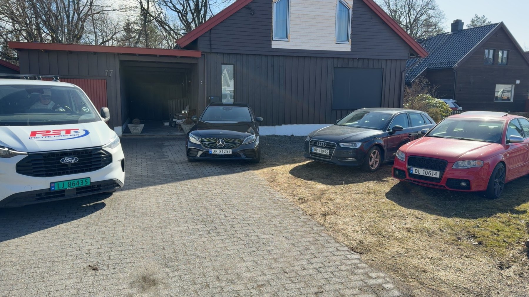 Flere biler foran hus